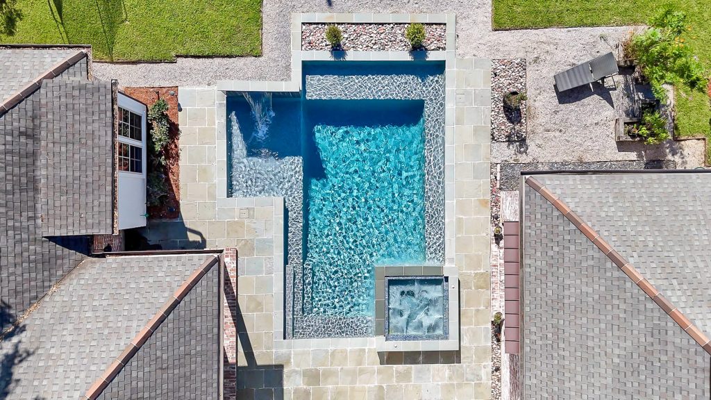 Top-down aerial view of luxury home swimming pool and outdoor living space