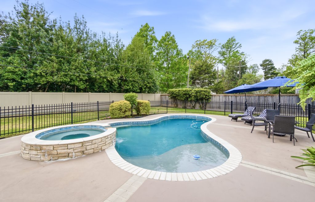Swimming pool with hot tub and backyard outdoor living area