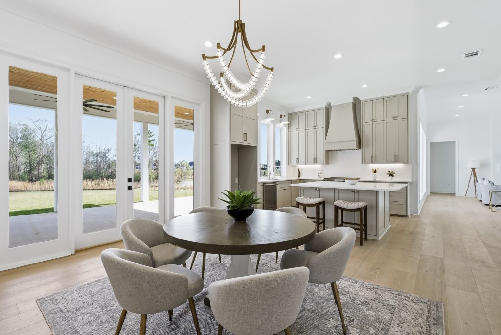 Bright dining area with kitchen visible in the background of an open floor plan