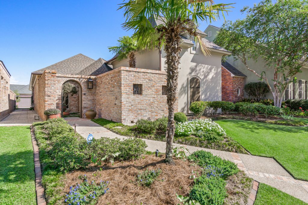 Luxury home exterior in University Club Baton Rouge with landscaped front courtyard entrance.