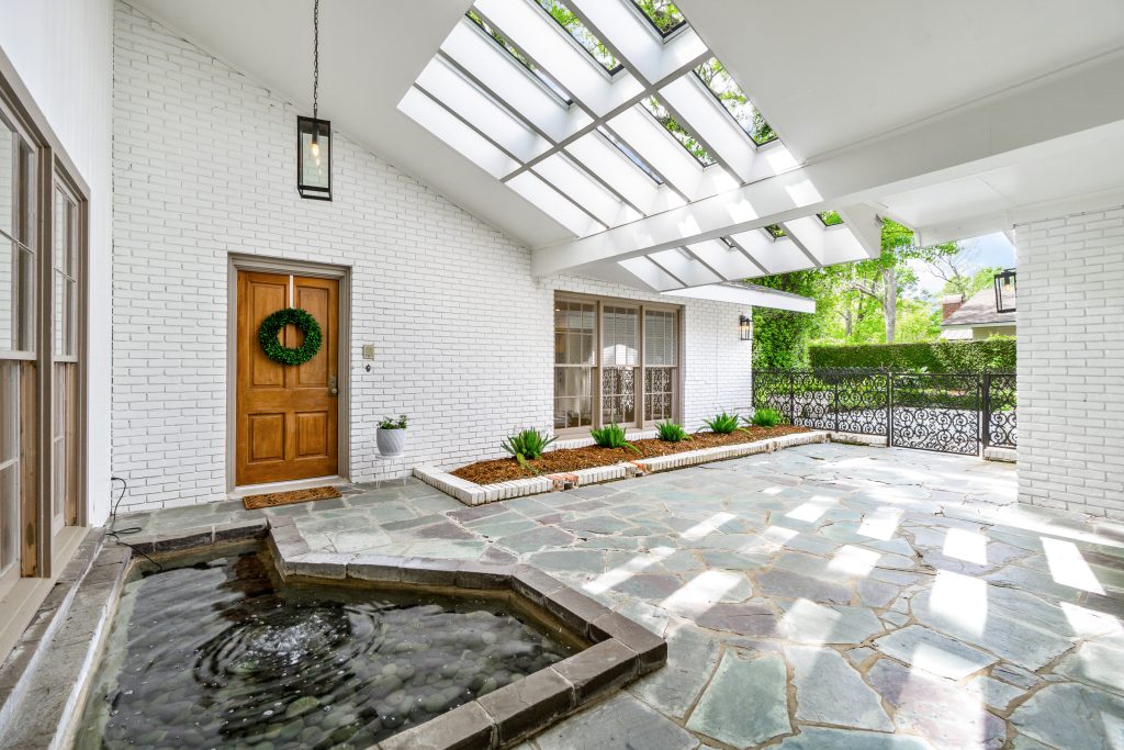 New Orleans-style courtyard with reflecting pool, skylights, and architectural outdoor living space.